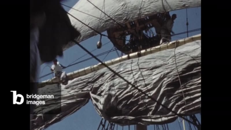 Image of 1960s: men on sailing ship pull ropes and adjust rigging